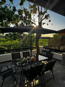 a table with chairs and an umbrella on a patio at KOHILI Seaside Residence in Polis Chrysochous