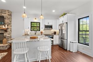 a kitchen with white cabinets and a large island with bar stools at Bear Paws in Townsend