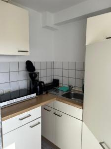 a kitchen with white cabinets and a sink at Break in Kudensee