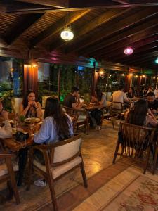Eine Gruppe von Menschen sitzt an Tischen in einem Restaurant in der Unterkunft Hotel Bella in Selçuk