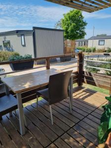 a wooden deck with a table and chairs on it at Camping L' Arlesienne in Arles