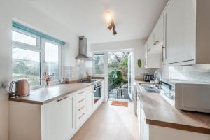 a kitchen with white cabinets and a large window at 2 Bed in Berrynarbor oc-l34468 in Berrynarbor