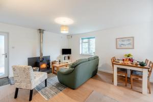 a living room with a couch and a table and a fireplace at 2 Bed in Berrynarbor oc-l34468 in Berrynarbor
