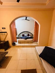 a bedroom with a bed and an arched window at The Wayside Inn in Matheran +4 photos