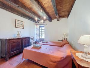 a bedroom with two beds and a table with a lamp at Holiday Home Le Petit Gîte by Interhome in Jayac