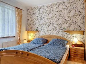 a bedroom with a bed with a blue comforter at Holiday Home Alexorella by Interhome in Godern