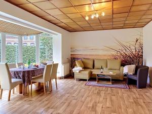 a dining room with a table and a couch at Holiday Home Alexorella by Interhome in Godern +29 photos