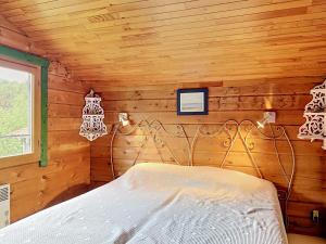 a bedroom with a bed in a wooden room at Holiday Home L'Escouarte by Interhome in Maubuisson