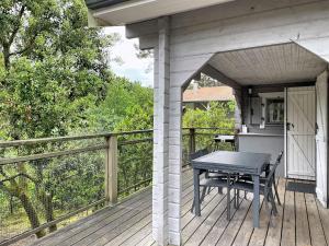 a wooden deck with a table and chairs on it at Holiday Home L'Escouarte by Interhome in Maubuisson