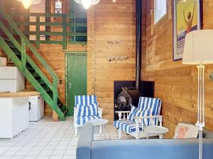 a living room with two blue chairs and a stove at Holiday Home L'Escouarte by Interhome in Maubuisson +26 photos