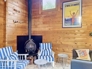 a living room with a wood paneled wall with a stove at Holiday Home L'Escouarte by Interhome in Maubuisson
