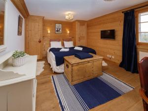 a bedroom with a bed and a tv in it at Chalet Saint Piran-1 by Interhome in Villars-sur-Ollon