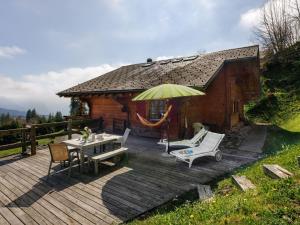 a wooden deck with a table and an umbrella at Chalet Saint Piran-1 by Interhome in Villars-sur-Ollon