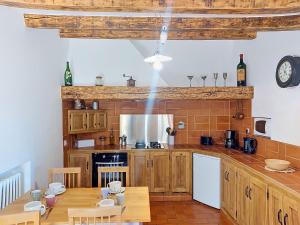 a kitchen with wooden cabinets and a wooden table at Holiday Home Chez Canard by Interhome in Ampus