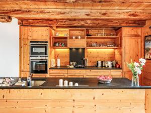 a kitchen with wooden cabinets and a black counter top at Chalet Saint Piran-1 by Interhome in Villars-sur-Ollon