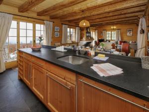 a kitchen with a sink and a living room at Chalet Saint Piran-1 by Interhome in Villars-sur-Ollon +52 photos