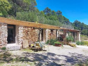 a stone house with a table and chairs outside at Holiday Home Chez Canard by Interhome in Ampus