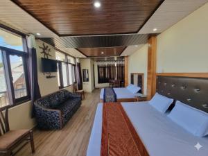 a hotel room with two beds and a couch at The Smarthill Sanctuary in Dalhousie +36 photos
