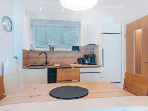 a kitchen with a wooden table and a white refrigerator at Apartment Sepp by Interhome in Bad Hofgastein