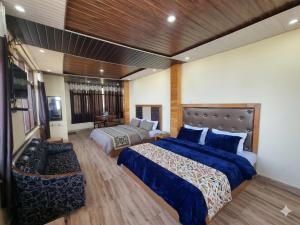 a hotel room with two beds and a couch at The Smarthill Sanctuary in Dalhousie