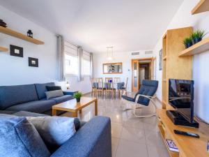 a living room with a blue couch and a tv at Apartment Nou Salou-1 by Interhome in Salou