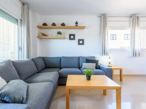 a living room with a blue couch and a table at Apartment Nou Salou-1 by Interhome in Salou +21 photos