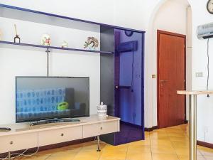 a living room with a tv and a blue door at Apartment Euroville-1 by Interhome in Germignaga