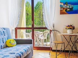 a room with a couch and a balcony with a table and chairs at Apartment Euroville-1 by Interhome in Germignaga