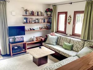 a living room with a couch and a table at Apartment Sassella 2a by Interhome in La Punt-Chamues-ch