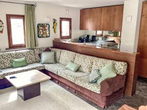 a living room with a couch and a kitchen at Apartment Sassella 2a by Interhome in La Punt-Chamues-ch