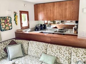a living room with a couch in front of a kitchen at Apartment Sassella 2a by Interhome in La Punt-Chamues-ch