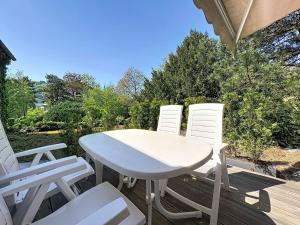 a white table and four white chairs on a deck at Holiday Home Moselhäuschen by Interhome in Traben-Trarbach