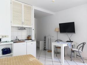 a kitchen with a table and a tv on the wall at Apartment Appartement A12 by Interhome in Traben-Trarbach