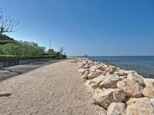a stone wall next to the water with a sidewalk at Holiday Home Aron by Interhome in Umag