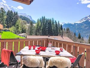 a table with chairs on a balcony with mountains at Apartment Racer's Retreat Apt-12 by Interhome in Wengen