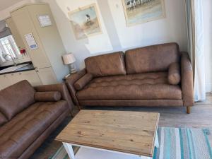 a living room with two brown couches and a coffee table at Sandy Bay Hideaway - Part of the The Bay Filey Holiday Village with pool, gym and direct beach access, pub, restaurant, tennis and meadows walks in Filey
