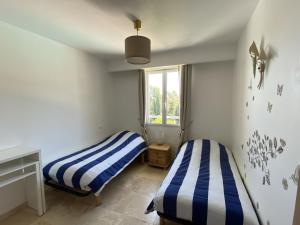 two beds in a room with a window at Apartment Le Domaine de la Baie-1 by Interhome in Cavalaire-sur-Mer