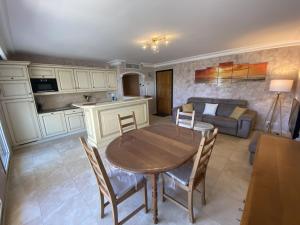 a kitchen and living room with a table and a couch at Apartment Le Domaine de la Baie-1 by Interhome in Cavalaire-sur-Mer