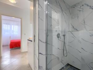 a bathroom with a shower with white marble walls at Apartment File-6 by Interhome in Zambratija