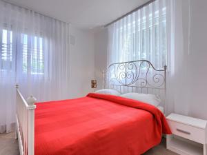 a white bedroom with a bed with a red blanket at Apartment File-6 by Interhome in Zambratija