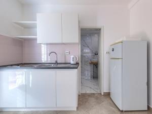 a white kitchen with a sink and a refrigerator at Apartment File-6 by Interhome in Zambratija +23 photos