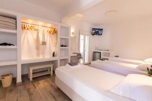 a room with two beds and a tv in it at Alexandra Suites - MYKONOS PORT in Mikonos +224 photos