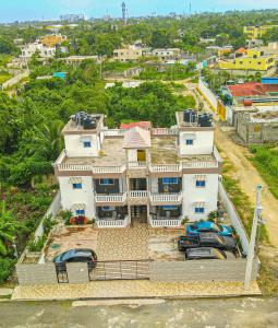 a large white house with cars parked in front of it at Residential Jula in Los Prados