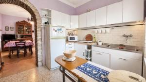 a kitchen with a white refrigerator and a table at Casa di Nonna in Montefranco