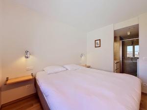 a bedroom with a large white bed in it at Apartment Wanderlust with garage by Interhome in Mispelburg