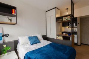 a bedroom with a bed with a blue blanket at Uliving Rio in Rio de Janeiro