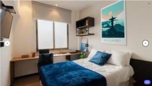 a bedroom with a bed and a desk in it at Uliving Rio in Rio de Janeiro