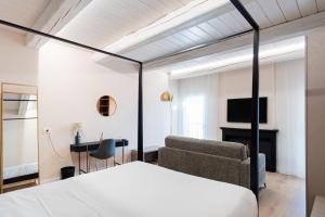a bedroom with a bed and a couch and a tv at B&B Le Suite del Corso in Lugo
