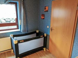 a childs bedroom with a wooden door and a window at Apartment Orpington by Interhome in Dreisbach