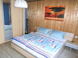 a bedroom with a bed with blue sheets and a painting at Apartment Orpington by Interhome in Dreisbach +18 photos